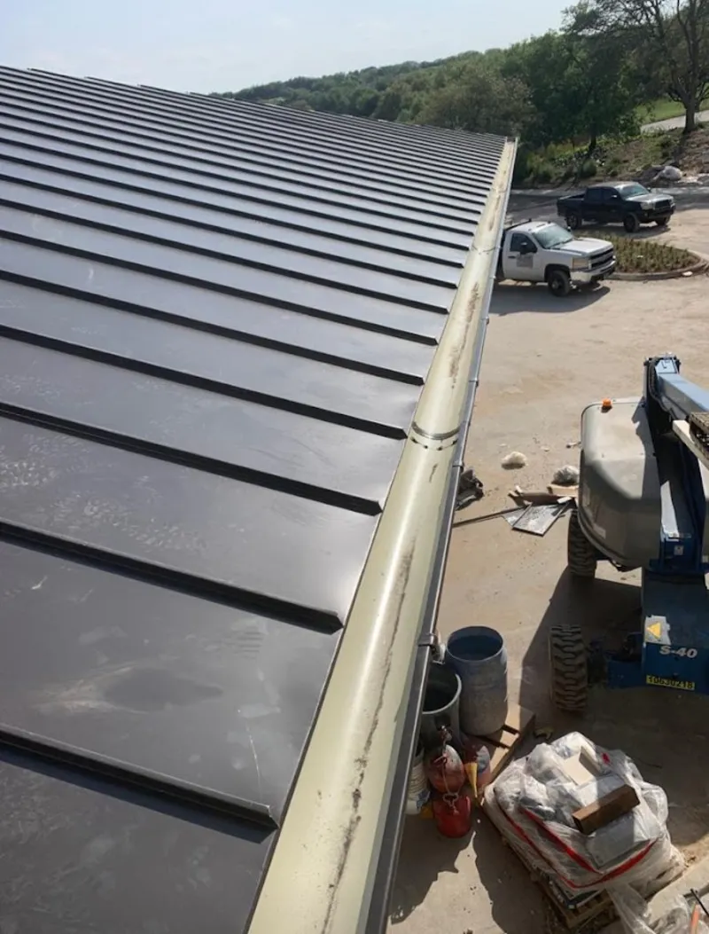 Standing seam panel and gutter detail on a metal roofing jobsite in Northville